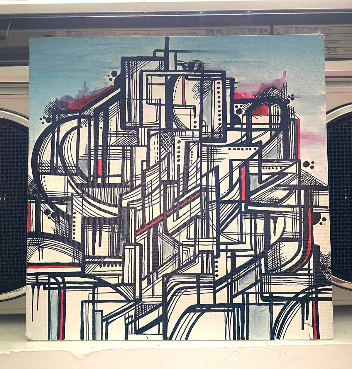 Composition abstraite géométrique aux lignes noires sur fond crème et bleu clair, avec des touches roses et rouges.