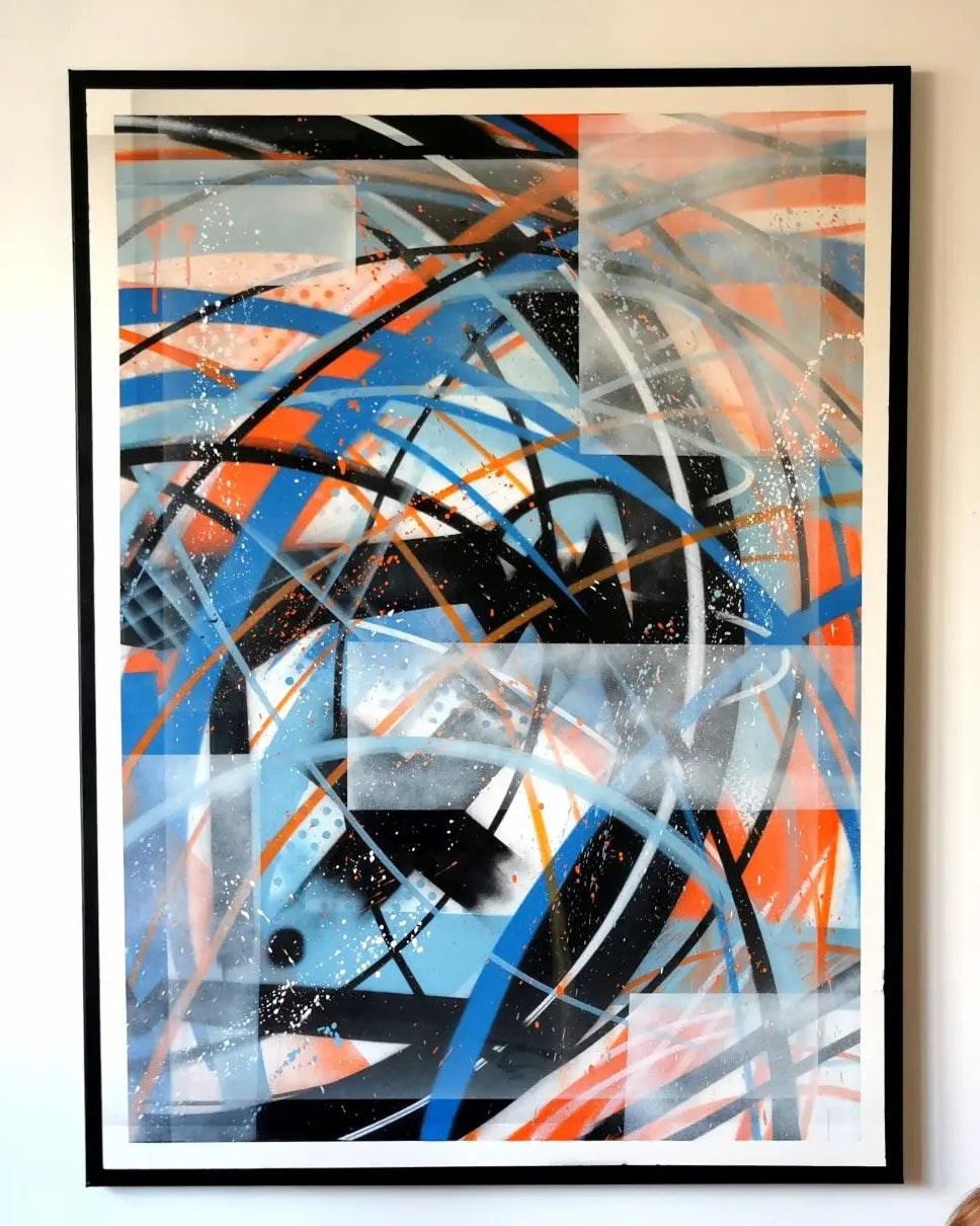 Abstraction avec logo par IPNSONE, composition abstraite bleue, orange, noire et blanche photographiée au mur dans un cadre noir.