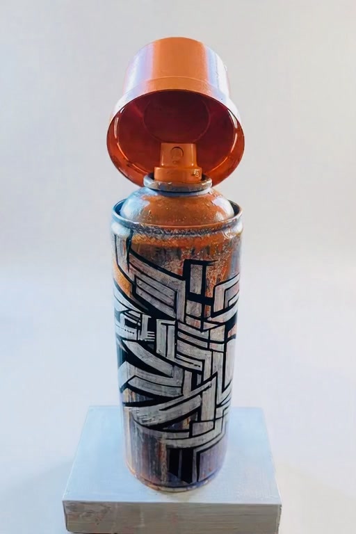 Bombe de peinture customisée par IPNSONE, lettrage géométrique noir et argent, capuchon orange, sur socle blanc